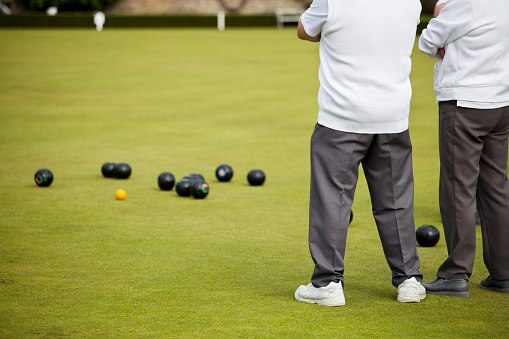 Players studying the position at a game of lawn green bowls