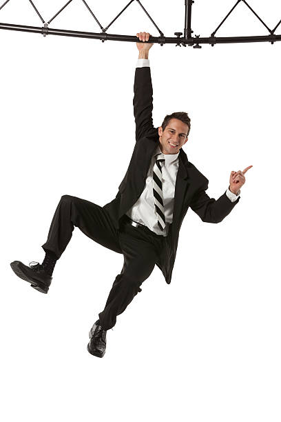 Businessman hanging from a metal structure