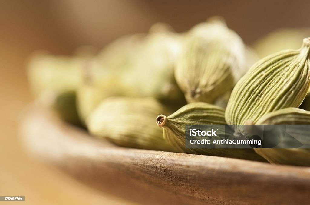 Green cardamom seeds in small wooden bowls Cardamom pods in a small wooden bowl Cardamom Stock Photo