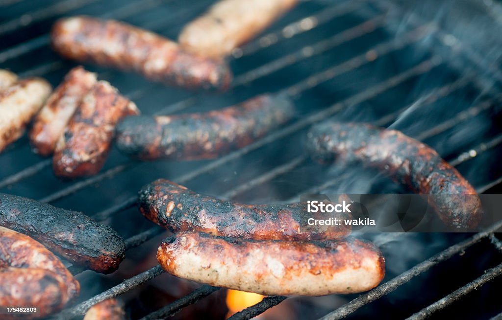 black bratwurst sausage "verbrannt" suitable for cancer pieces of meat and sausages on fired barbeque grill Burning Stock Photo
