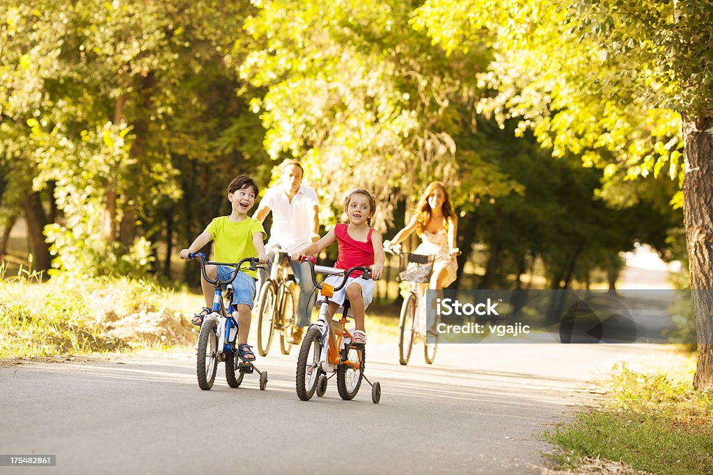 Familia feliz, montar una bicicleta al aire libre. - Foto de stock de Accesorio de cabeza libre de derechos