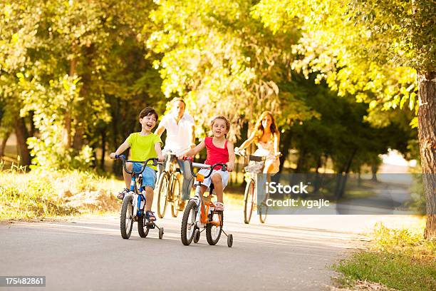 Familia Feliz Montar Una Bicicleta Al Aire Libre Foto de stock y más banco de imágenes de Accesorio de cabeza - Accesorio de cabeza, Actividad, Actividades recreativas