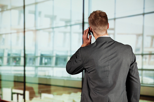 Rear vew of a businessman talking on mobile phone