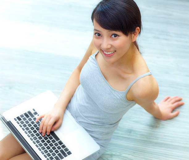 istock pretty young woman using laptop in home 175484502