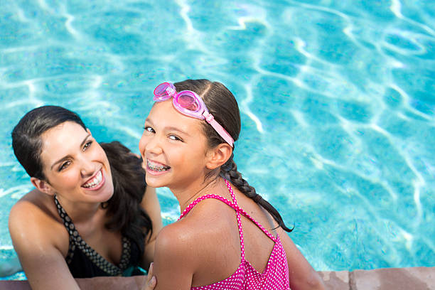 madre e hija en la piscina - early teens child swimming pool swimming fotografías e imágenes de stock