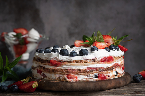Fruit juicy cream cake with biscuit, cream cheese, strawberries, blueberries and whipped cream. Refreshing dessert