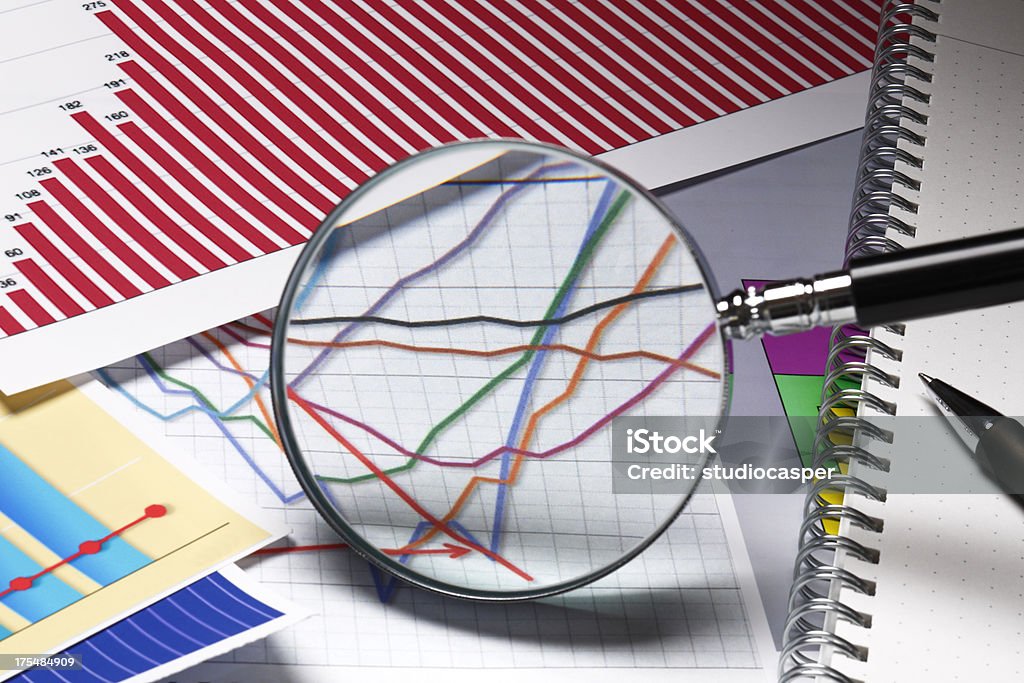 graphs and charts "Magnifying glass,on business graph" Graph Stock Photo