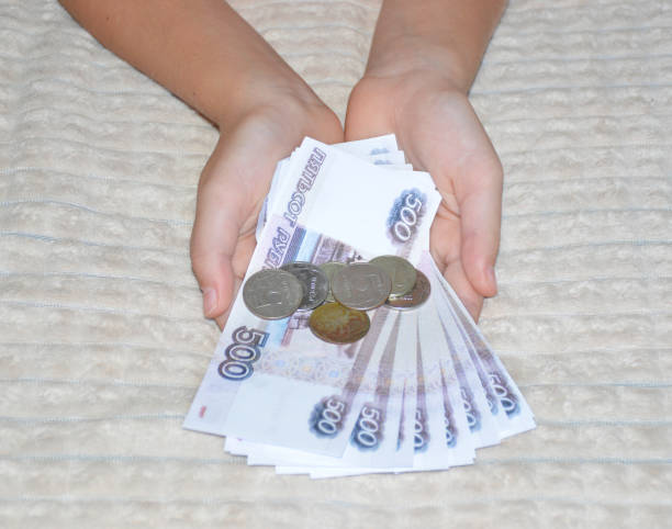 istock Russian rubles and coins in female hands 1754849324