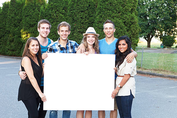 istock Six young adult students outside holding a banner. 175485018