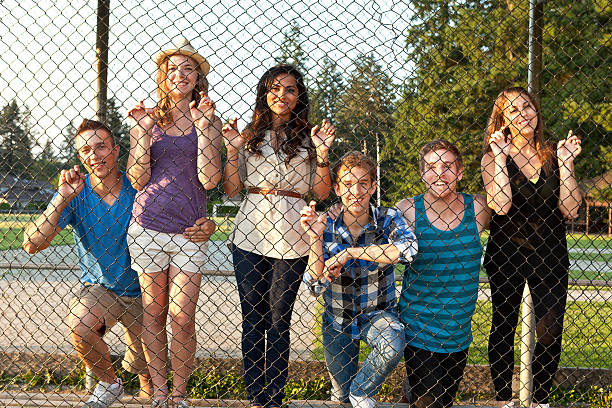 istock Group of college friends looking through a wire fence 175485038