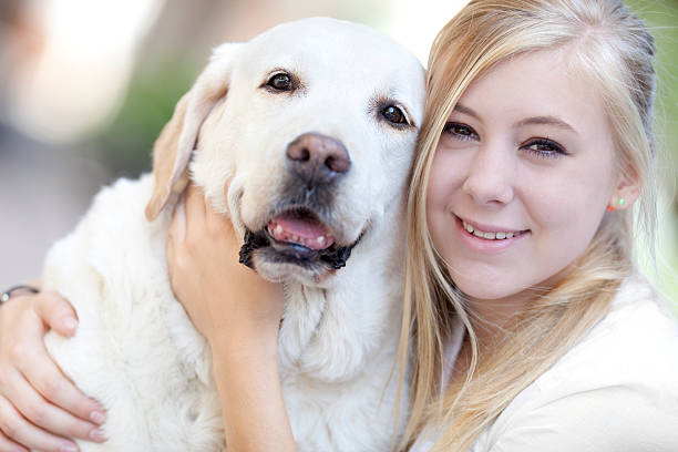 istock hug between girl and white labrador 175485464