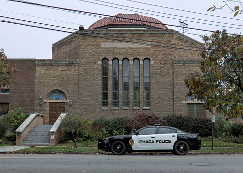 Ithaca, NY - Oct 22, 2023: Police cruiser car parked on in front of Jewish Temple Beth El in the Finger Lakes region of Upstate New York.