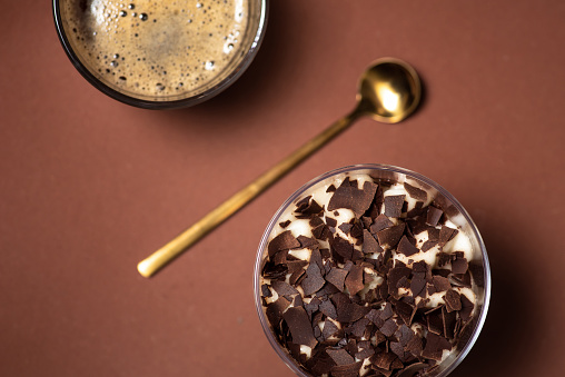 Cocoa beans and heap of Cocoa powder with small wooden scoop in it isolated on a white background.