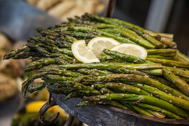 Yummy Asparagus for Dinner with Lemon Slices and Seasoning Flavor Close up shot of cooked and fried asparagus ready to be eaten. Healthy food choices concept. Eat your veggies! asparagus organic dinner close to stock pictures, royalty-free photos & images