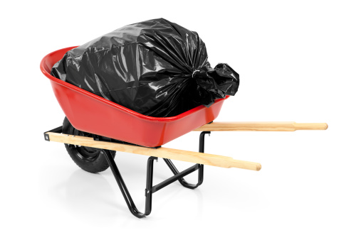 Red wheelbarrow with a trash bag inside. Isolated on white.Please also see: