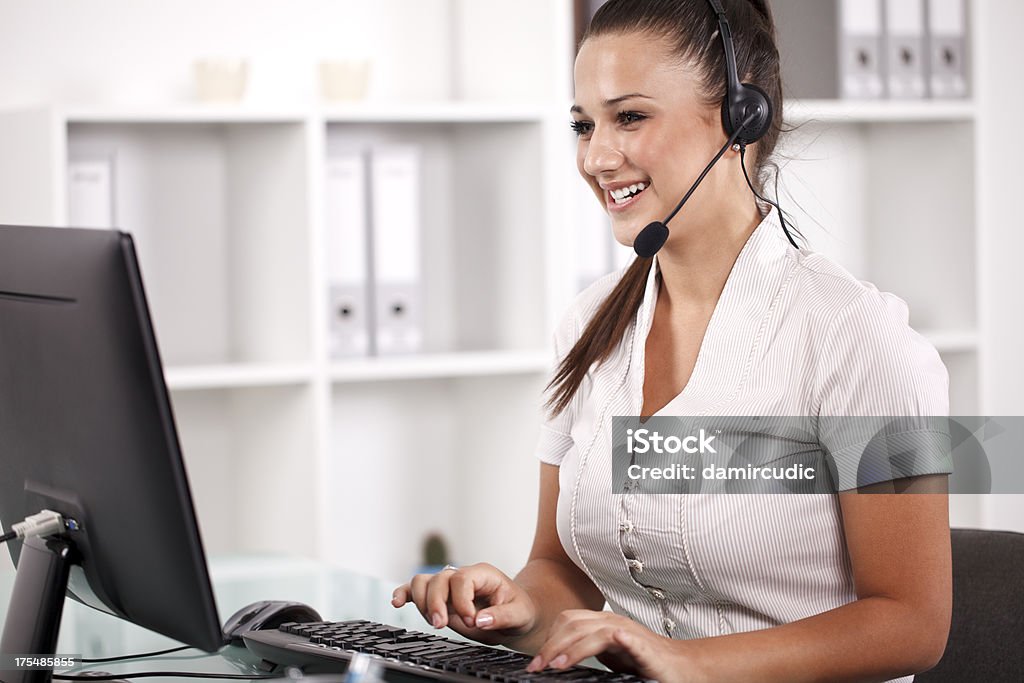 Junge weibliche call center Betreiber während Telefongespräch - Lizenzfrei Arbeitspersonal Stock-Foto