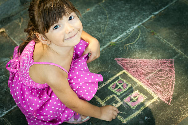 vista aérea de girl drawing en la acera - little girls sidewalk child chalk fotografías e imágenes de stock