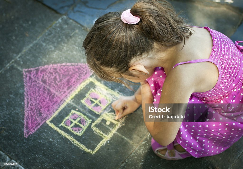 Little Girl Drawing en la acera - Foto de stock de Dibujo a la tiza libre de derechos