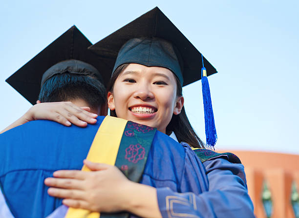 istock young university graduate hugging her friend at graduation 175486524
