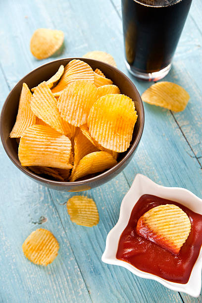 Potato chips with ketchup and a cola