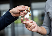 Close-up on a real estate agent giving a man the keys of his new house