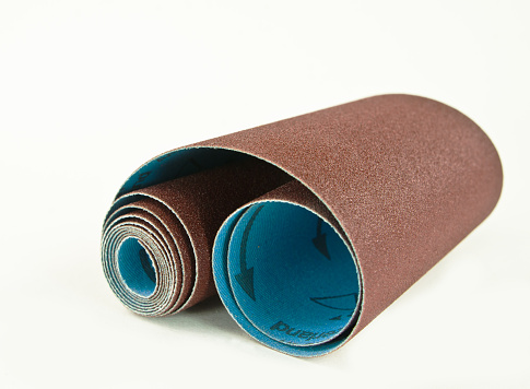 A roll of woodturners and carvers cloth-backed sand paper with a white background and copy space.