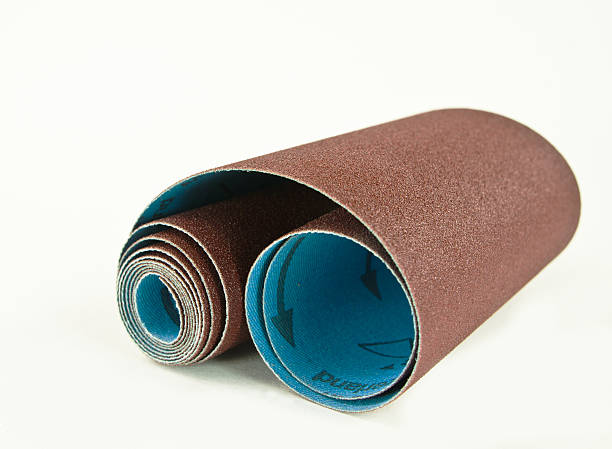 Sand Paper Roll A roll of woodturners and carvers cloth-backed sand paper with a white background and copy space. sand paper stock pictures, royalty-free photos & images