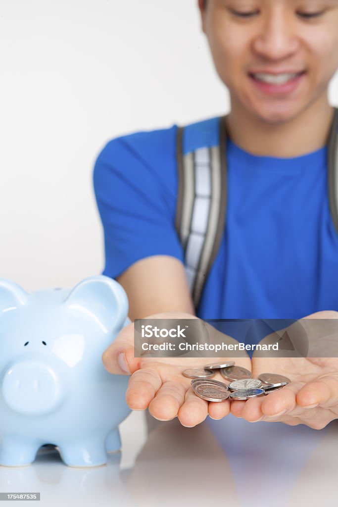 Estudante do sexo masculino sorridente com moedas em palm - Foto de stock de 16-17 Anos royalty-free