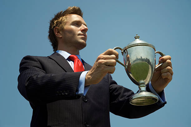 istock Proud Businessman Holds Silver Trophy Blue Sky 175487604