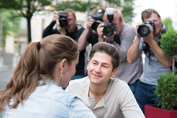 istock Young couple being photographed paparazzi style 175487770