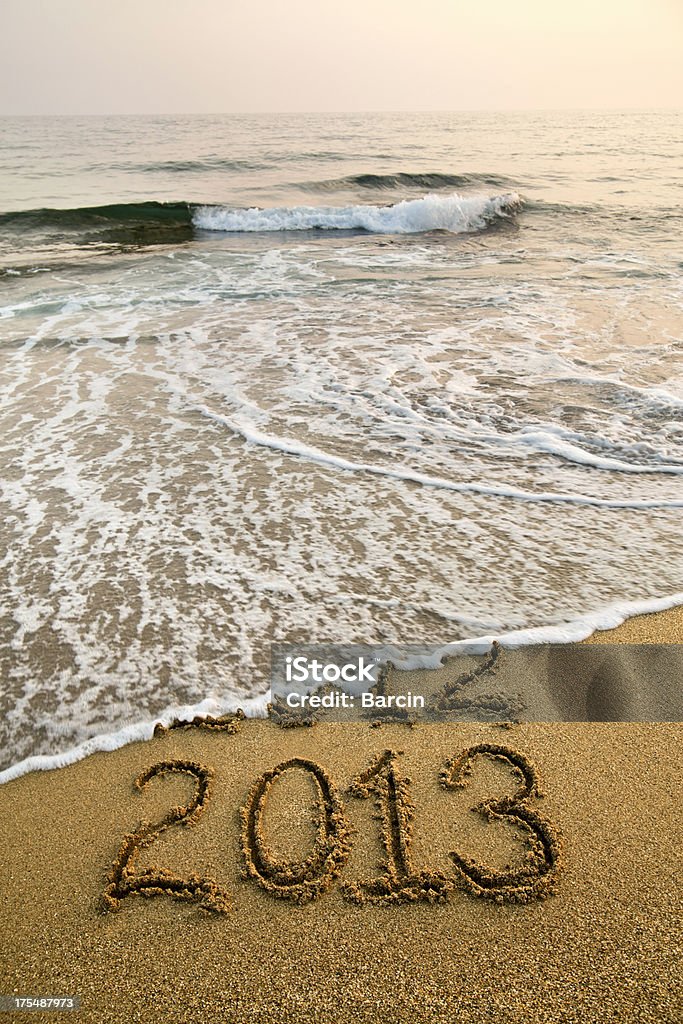 2013 y 2012 escrito en la playa con olas - Foto de stock de 2012 libre de derechos