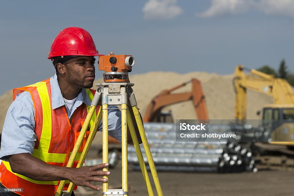 Surveyor at Site An image from the construction industry of a surveyor and transit. Surveyor Stock Photo