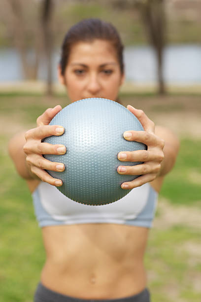 istock Young athletic woman in park with exercise ball 175488614