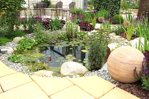 Worlington, Suffolk, England - Sept 11 2018: Landscaped house garden with ornamental pond and patio