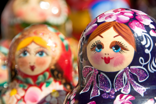 Matryoshka dolls decorated with patterns stand in a row. A cultural symbol. Human appearance.