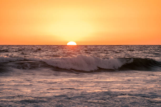 istock The Sun sets behind the waves of the Pacific Ocean 1754895604