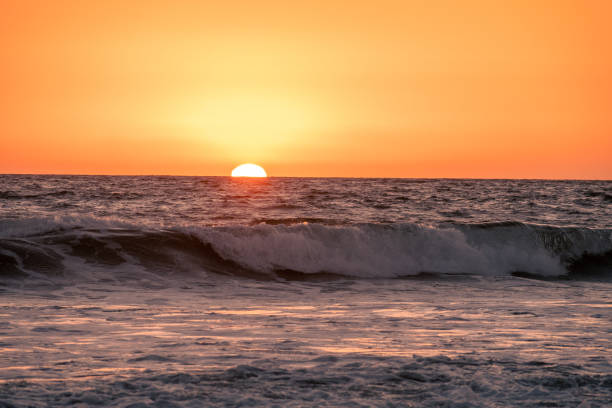 istock The Sun sets behind the waves of the Pacific Ocean 1754896150