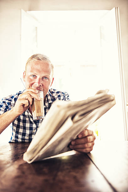homme lisant les actualités - latte machiatto photos et images de collection