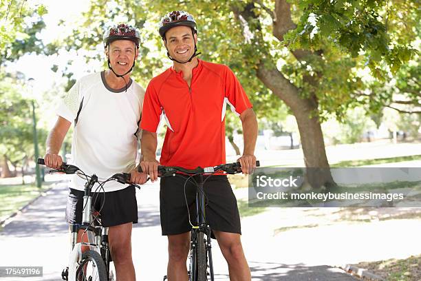 Dois Homens Ciclismo Através De Um Parque - Fotografias de stock e mais imagens de 30-39 Anos - 30-39 Anos, 50 Anos, Adulto