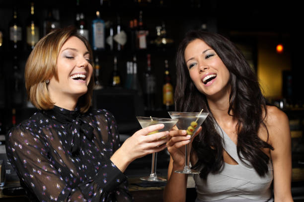 Two Young Women Toasting Drinking Martinis in Bar