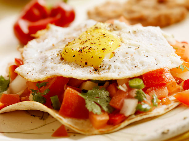 Huevos Rancheros "Huevos Rancheros on Grilled Tortillas with, Fresh Salsa, Refried Beans and Mexican Rice - Photographed on Hasselblad H3D2-39mb Camera" omelet rustic food food and drink stock pictures, royalty-free photos & images