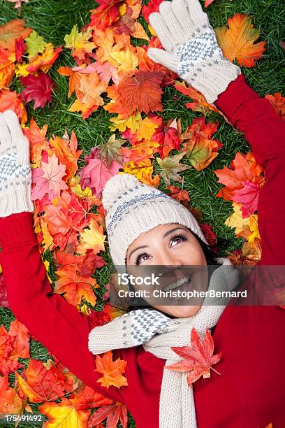 Foto de Mulher Sorridente Colocar Em Folhas De Outono e mais fotos de stock de 20-24 Anos - 20-24 Anos, Adulto, Alegria