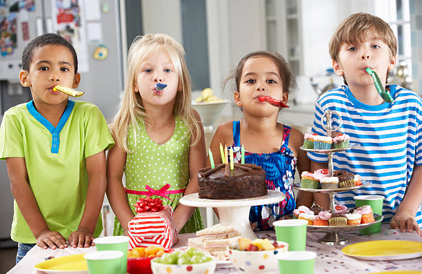 istock Children Standing By Table Laid With Birthday Party Foo 175491618