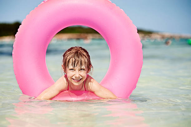 rapariga e rosa tubo de piscina no mar. - swimming tube inflatable circle imagens e fotografias de stock