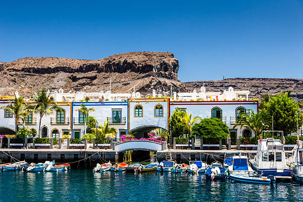 Grand Canary Puerto de Mogan "Colorful waterfront houses at the harbor of Puerto de Mogan with small motor boats, Puerto de Mogan,Gran Canaria Island, Canary Islands, Spain." grand canary stock pictures, royalty-free photos & images