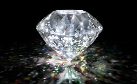 Diamond on a black background with prism caustic reflections.