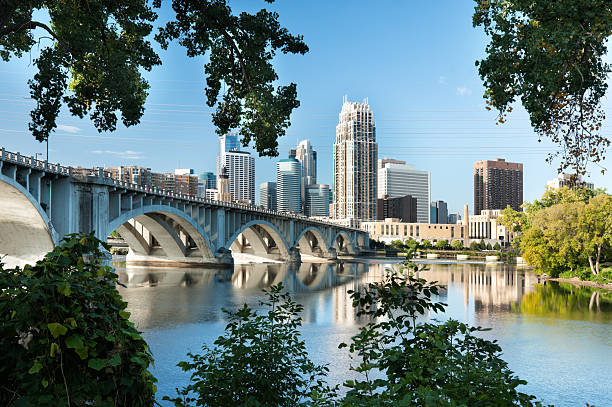 Minneapolis, Minnesota with 3rd Ave. bridge. "Cityscape view of Minneapolis, Minnesota during a blue sky summer day. View from River Place on the opposite bank of the Mississippi river looking Southwest." minneapolis stock pictures, royalty-free photos & images