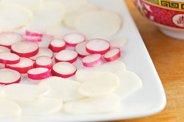Sliced Red Radishes and Turnips on White Plate Sliced red radishes and white turnips on white plate sprinkled with salt and sugar. pickled turnip stock pictures, royalty-free photos & images