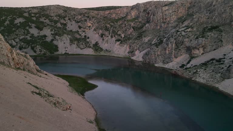 The rocky canyon walls which flank the Zrmanja River rush by as this drone shot approaches the water