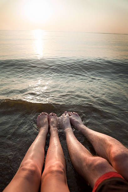 mann und frau beine in beach - human foot wading sea human toe stock-fotos und bilder